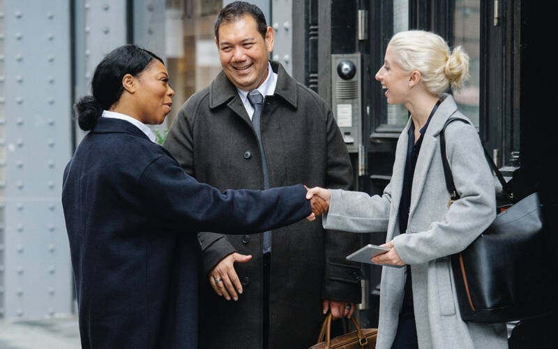 Picture of business men and women shaping hands outside business premises