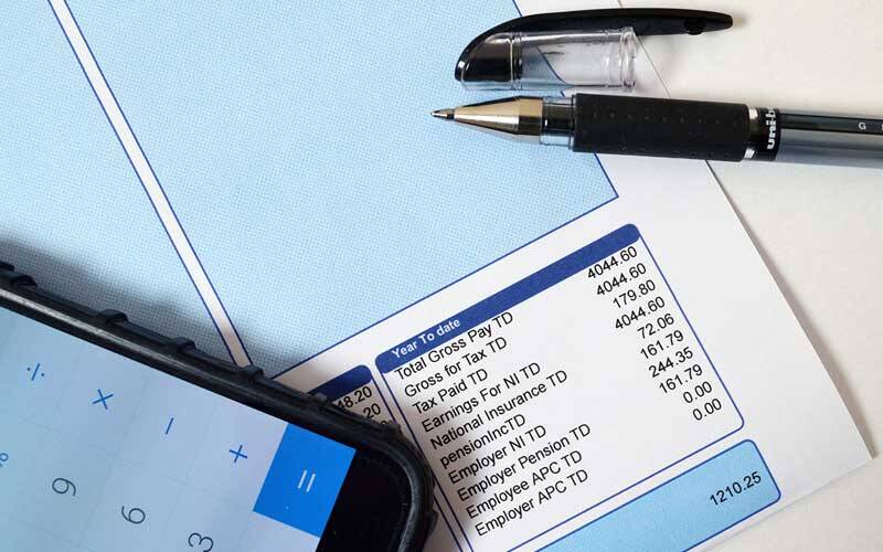 Picture of payslip with mobile phone calculator application open