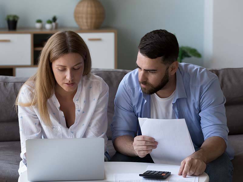 Picture of man and woman looking at papers and laptop
