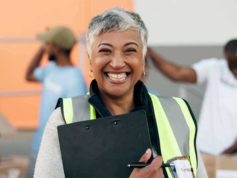 Femaile charitty volunteer wearing high-visability vest