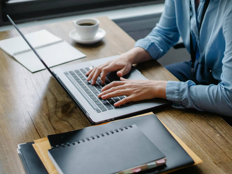 Person working at their desk using laptop computer