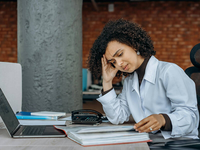 Frustrated business owner sat at their desk with a headache