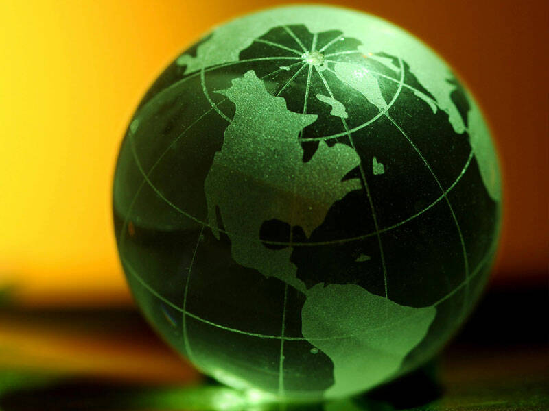 Green glass globe resing on a table top