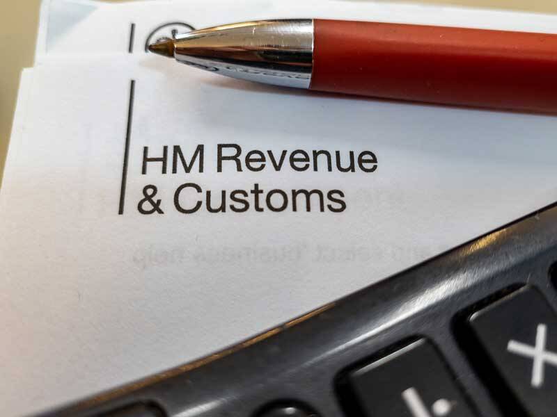 Header paper with HM Revenue & Customs with a pen and calculator resting on top