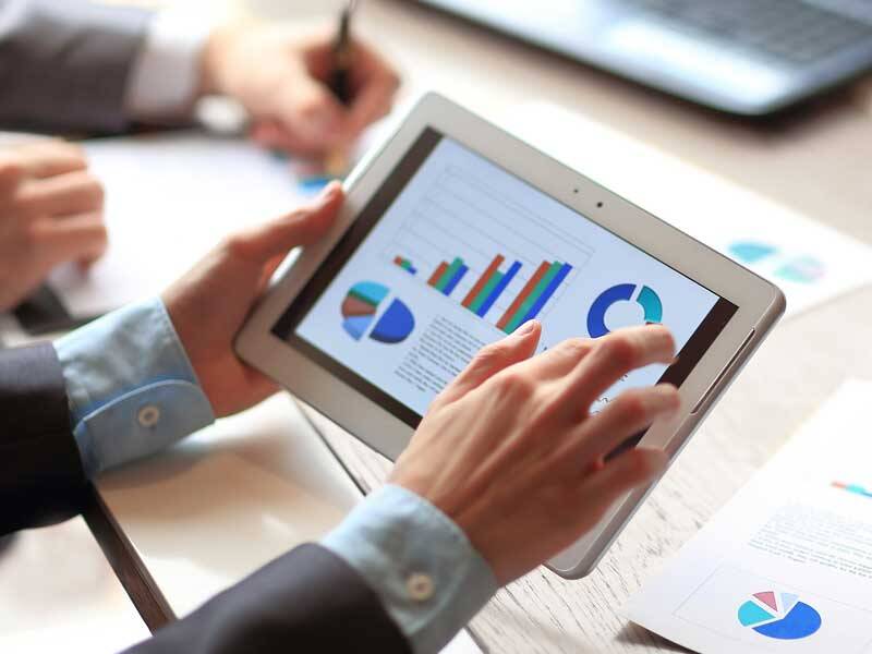 Business men looking at charts and information on the screen of a tablet computer