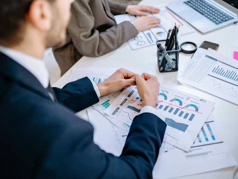 Business men and woman in a busines meeting and looking at paper based charts and information