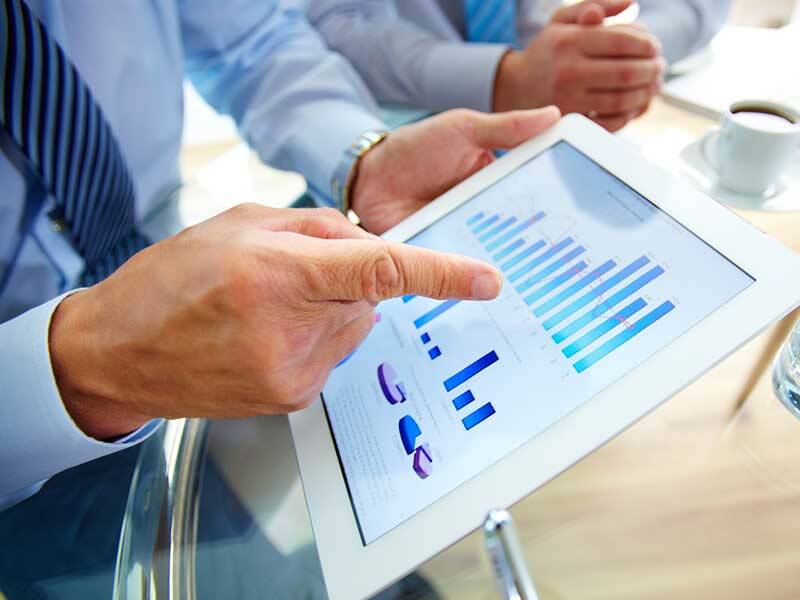 Business man pointing to charts and figures on the screen of tablet computer