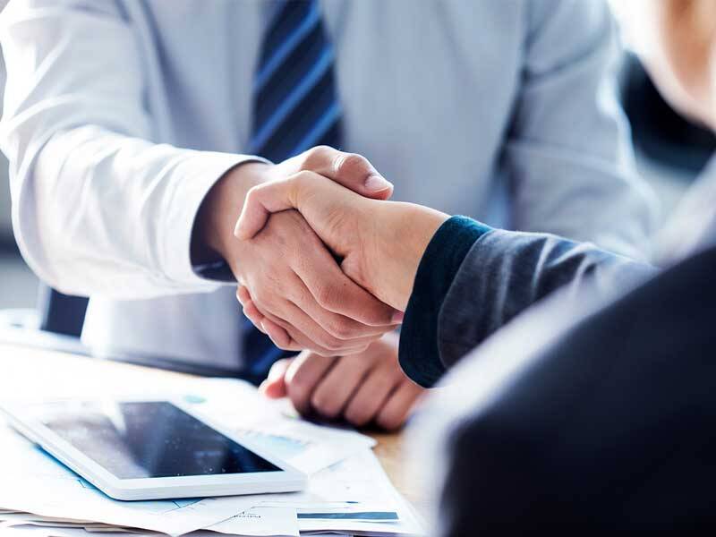 Collaborating business men shaking hands in agreement