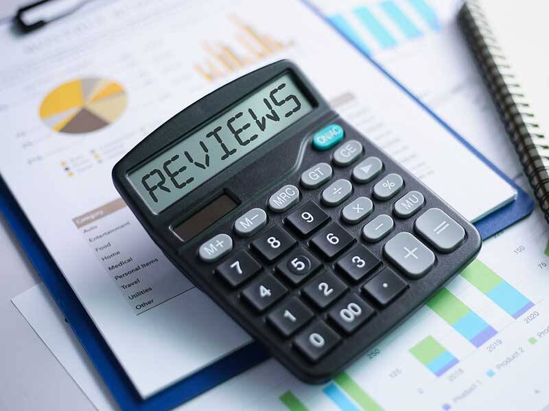 Calculator with the word Review written in the screen along wth charts and information on paper