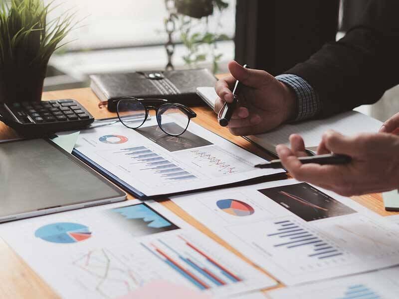 Business men looking at charts and information on paper