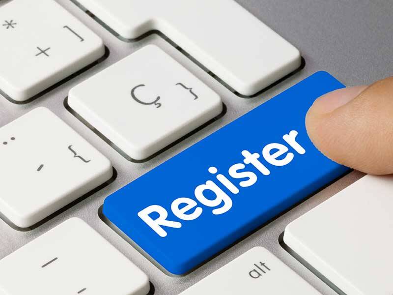 Person pointing at a blue computer keyboard key with Register written on it