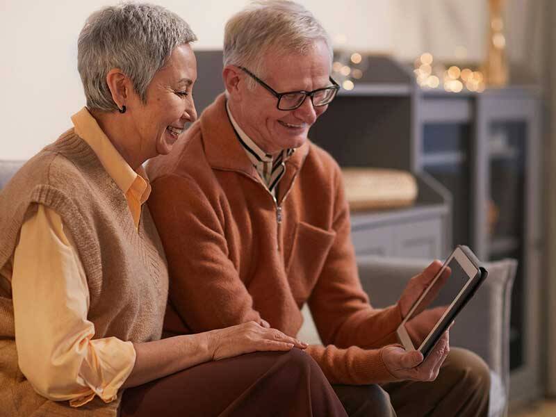 Happy pensioners and senior citizens looking at tablet computer screen