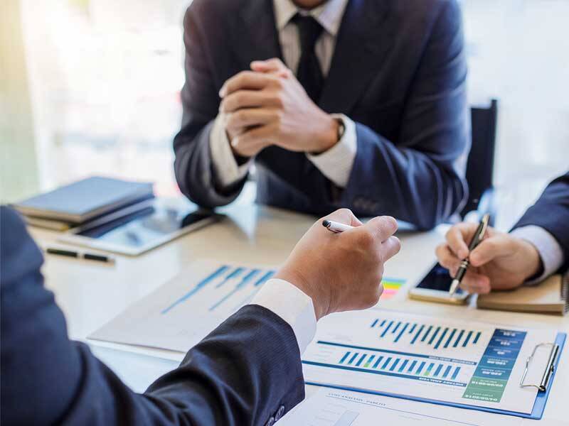 Business men holding a meeting and reviewing charts and information