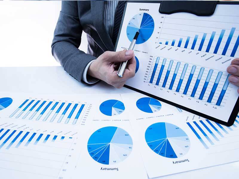 Business man pointing to paper based charts and information