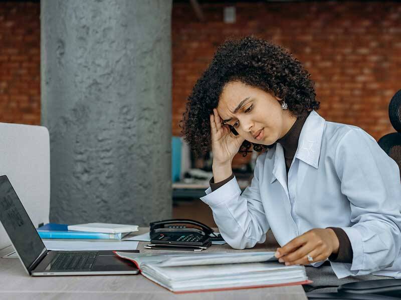 Business woman looking worried while looking at looking at charts and figures on paper
